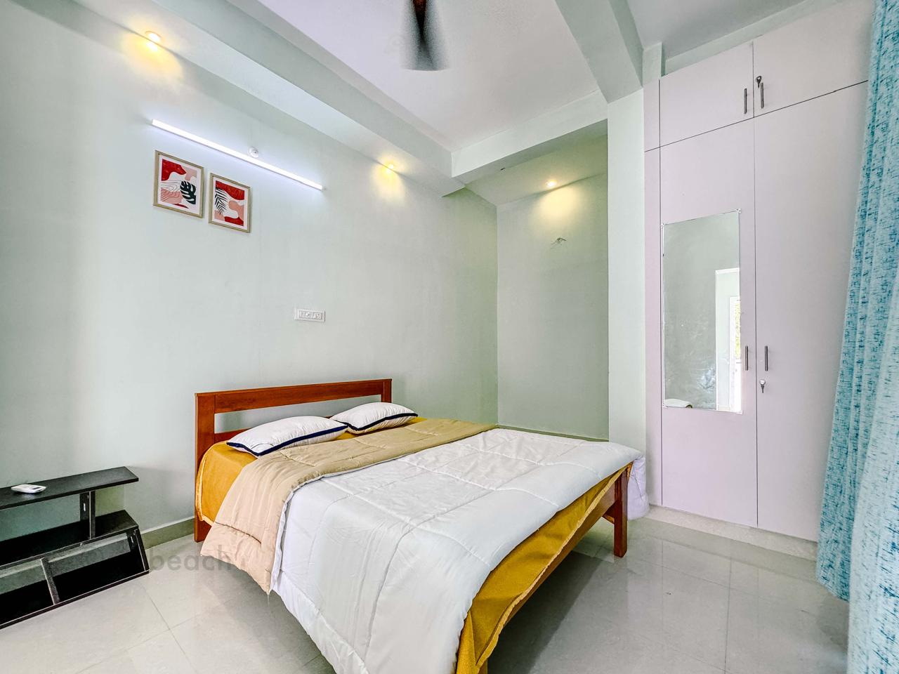 A modern bedroom featuring a wooden bed with white and yellow bedding and a white wardrobe.